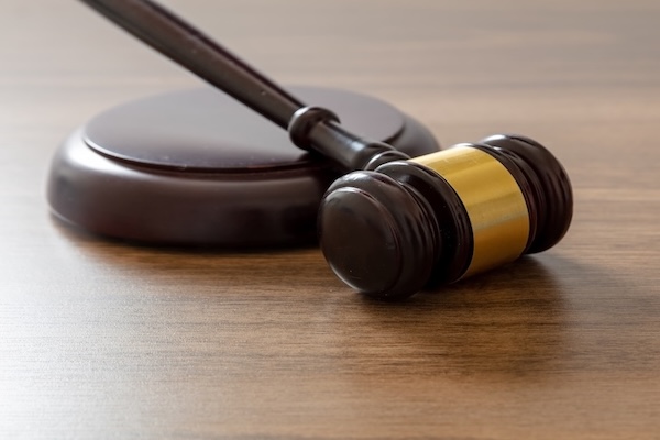 Judge gavel on lawyer office desk. Law or auction concept. Wooden courthouse table, close up view, copy space.